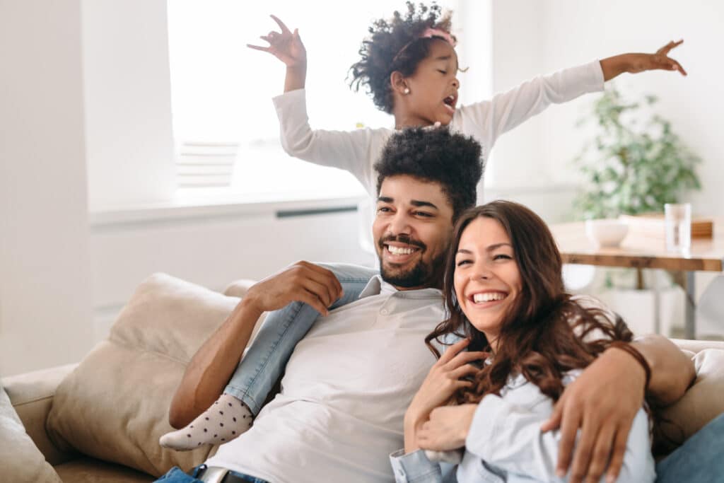 Happy family sitting and laughing on couch together