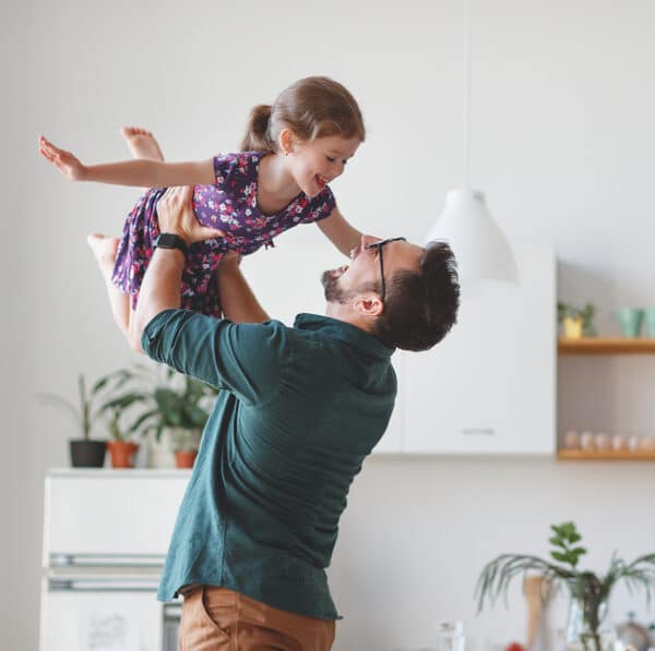 Dad holding daughter in the air
