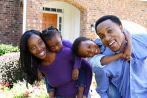 Happy family in front of home